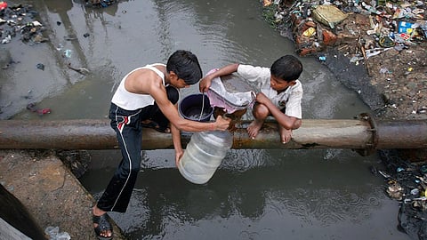 रिसती पाइप लाइन से पीने के लिए गंदा पानी भरने को मजबूर बच्चे।