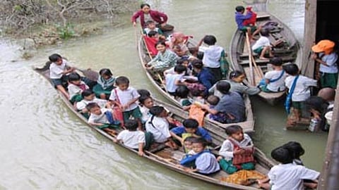 बाढ़ की वजह से नाव पर स्कूल जाते बच्चे
