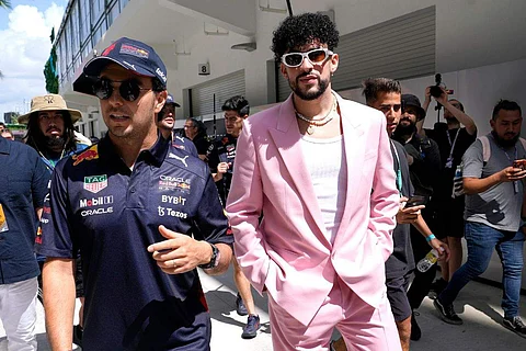 Red Bull driver Sergio Perez, of Mexico, left, walks with Puerto Rican reggaeton musician Bad Bunny before a Formula One Miami Grand Prix auto race