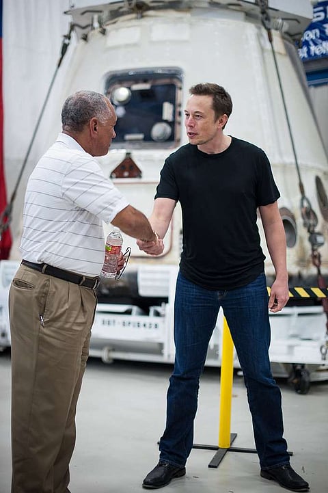 Elon Musk shaking the hands of Charles Bolden.