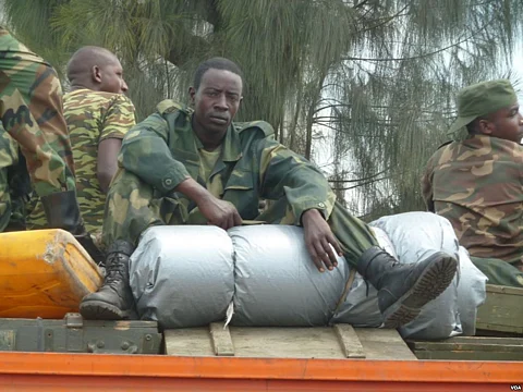 An M23 soldier rests on boxes of ammunition as the group withdraws from the Congolese city of Goma, Dec. 1, 2012