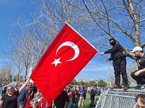 On March 29, 2025, a protester on police barricades holding a Turkish flag participated in the Freedom for İmamoğlu rally organized by the CHP.