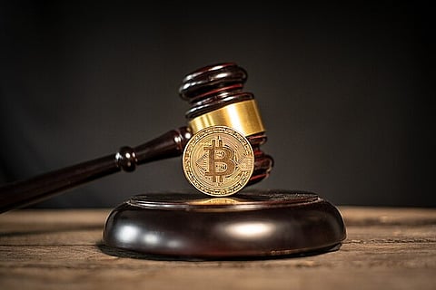 Photo featuring a Bitcoin cryptocurrency medallion and a judge's gavel, used to represent the concept of Bitcoin crypto laws and regulations.
