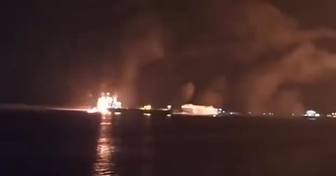 A fiery explosion lights up Yemen's Ras Issa fuel port under US airstrikes, with thick smoke rising from the blazing site.