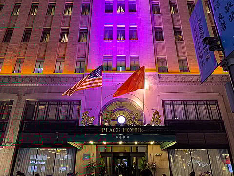 Flags of China & the USA in front of the Peace Hotel, Shanghai