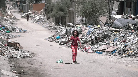 A Palestinian girl walks through Gaza's ruins