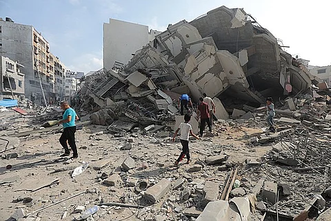 Palestinians inspect the ruins of Aklouk Tower destroyed in Israeli airstrikes in Gaza City on October 8, 2023.