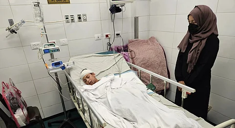 Dr. Alaa al-Najjar, a pediatrician at Nasser Hospital in Gaza, watches over her 11-year-old child, critically wounded in a devastating Israeli airstrike that killed her nine other children.