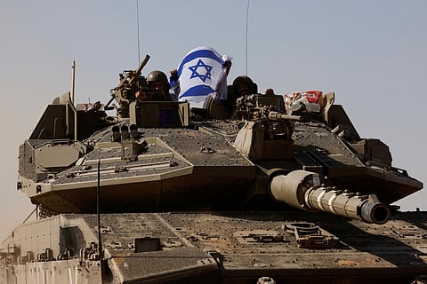 Israeli tank with a soldier waving the Israeli flag.