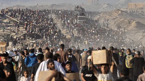 A mass exodus of people from Gaza, carrying belongings, amid a humanitarian crisis worsened by over 19 months of ongoing genocide.