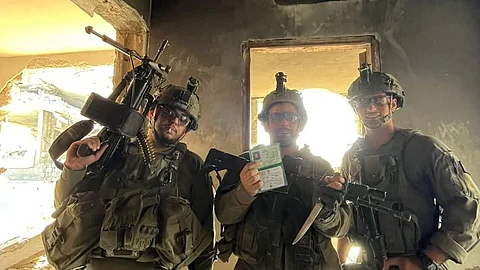 Israeli soldiers pose with a Palestinian woman’s ID, one gripping a knife, amid the ongoing invasion. The woman’s fate is unknown.