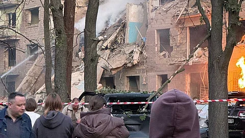 A building reduced to rubble after a Russian missile strike, with emergency crews and onlookers amid the chaos, June 23, 2025.