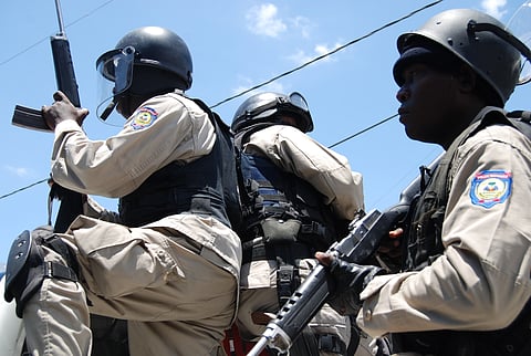 Haitian National Police ready their unit to search for gunmen who fired shots into the air during a protest march.