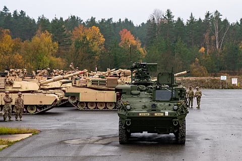 A green army vehicle with a background of tanks in Germany