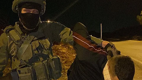 A soldier from Israel's Kfir Brigade abducting a Palestinian teenager during an illegal night raid in the Occupied West Bank.