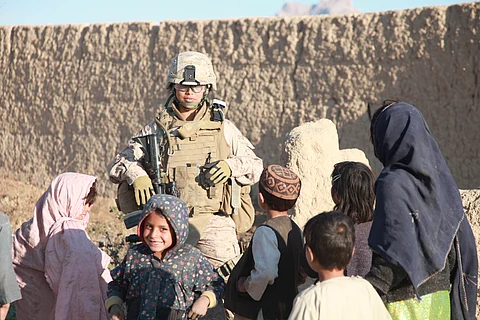 US soldier standing with afghan kids