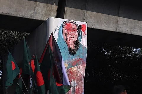 A protest scene where Sheikh Hasina's portrait becomes a focal point of public dissent, with individuals throwing shoes as a symbolic act of hatred and resistance against her regime.