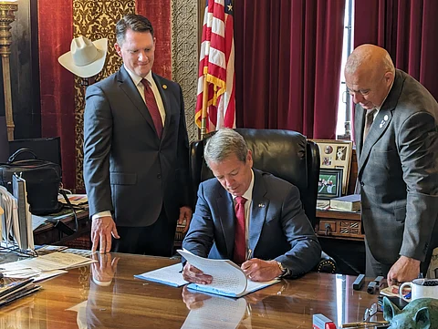 Governor Jim Pillen signs Legislative Bill 514 in his office, implementing photographic voter identification in Nebraska, as Senators Ben Hansen and Tom Brewer look on, June 2023.