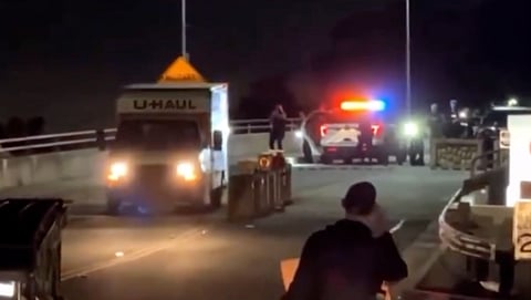 The truck drove erratically and backed into barriers amid flashing police lights.