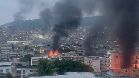 Plumes of smoke seen from burning vehicles and structures amid urban combat.