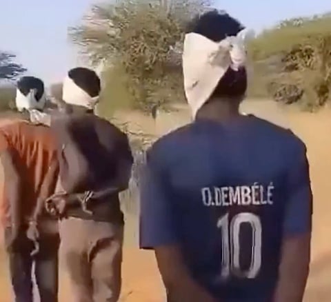 Individuals under RSF control, walking with their hands tied behind their backs and blindfolded.