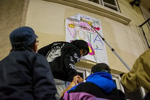 Activists pasting posters during the 2025 Ecuadorian constitutional referendum campaign in Cuenca, Ecuador.