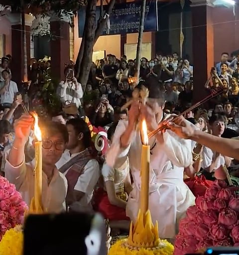 Cambodians pray at the University of Fine Arts, involving candles, incense, offerings for border protection.