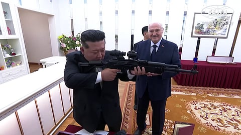 Kim Jong-un holds a firearm during Lukashenko's state visit.