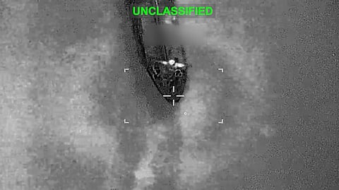 Black-and-white infrared targeting video from a U.S. aircraft showing an aerial view.