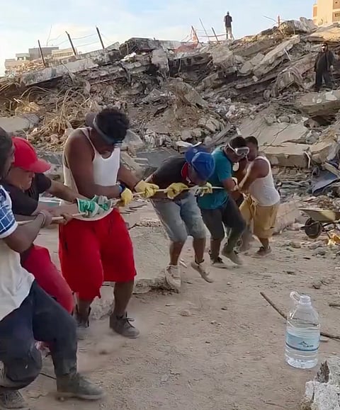 Venezuelan volunteers use ropes to manually clear rubble from earthquake-damaged buildings after the June 24, 2026 twin quakes.