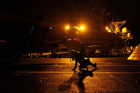 U.S. Sailors signal an F/A-18E Super Hornet on the deck of USS George H.W. Bush (CVN 77) as the aircraft carrier transits the Arabian Sea