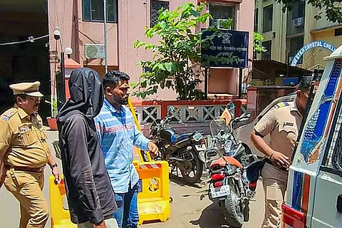 Police personnel take 56-year-old accused Manoj Sane into custody for killing his live-in partner in Mumbai.