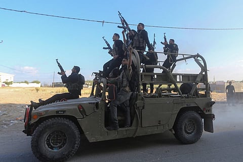 Palestinian militants ride an Israeli military vehicle that was seized by gunmen who infiltrated areas of southern Israel, in the northern Gaza Strip.