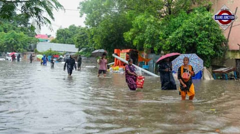 Pedestrians on a waterlogged road amid rain in Chennai on Tuesday, October 15.