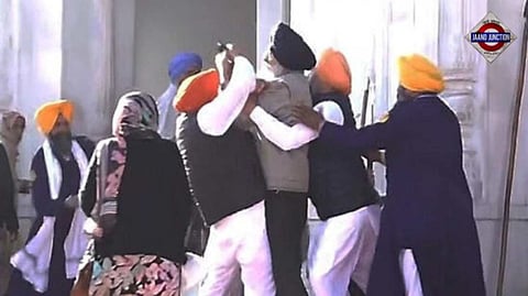 People catch a man who allegedly opened fire at Shiromani Akali Dal leader Sukhbir Singh Badal while the latter was serving the 'tankhah'