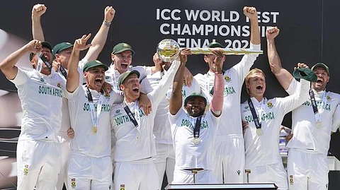 South Africa’s captain Temba Bavuma holds the winner’s trophy and celebrates with teammates on the podium after their win in the World Test Championship final (WTC) against Australia at Lord’s cricket ground in London, Saturday, June 14, 2025