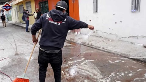 Votive candles are placed near the bullet-riddled house where gunmen opened fire during a party celebrating in Mexico.