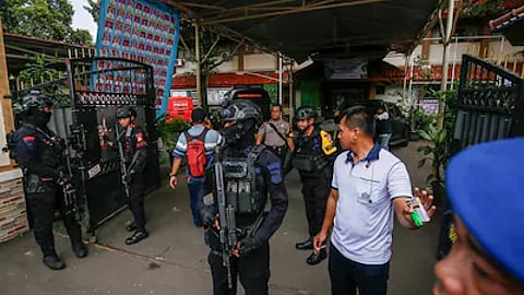 Bomb squad officers stand guard at the entrance of a school in Jakarta on November 7.