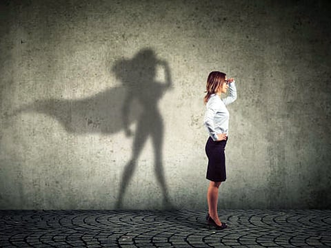 Side view of a business woman imagining to be a super hero looking aspired.