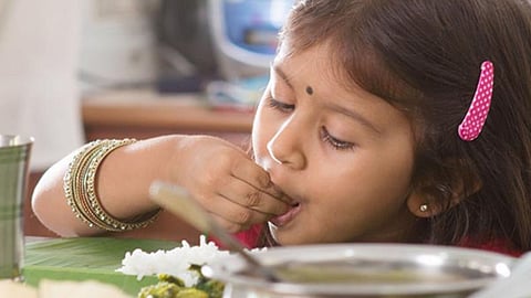 கையால் உணவு சாப்பிடும் குழந்தை