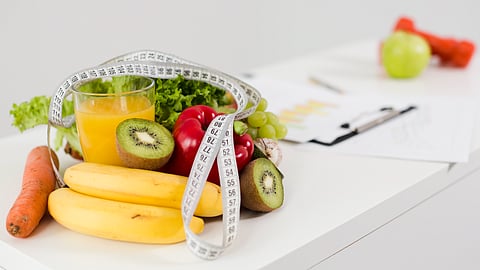Fresh fruits, vegetables with a measuring tape