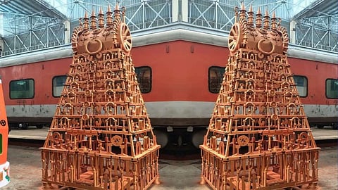 Two ornate temple replicas with a red train in the background.