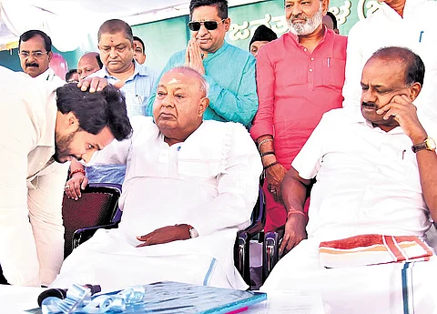 JDS Youth Wing president Nikhil Kumaraswamy seeks blessings of his grandfather and party supremo HD Deve Gowda, as his father and Union Minister HD Kumaraswamy looks on