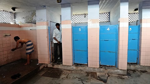 A Indian man washes as another comes out of a toilet in a toilet complex run by an NGO Sulabh International at railway station in New Delhi in 2011.