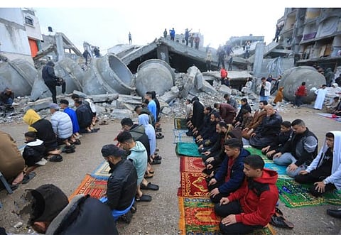 Children and adults offering Eid prayers amid rubble in war-torn Gaza.