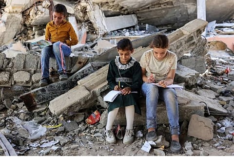 Children studying in open spaces of destroyed infrastructure of schools in Gaza.