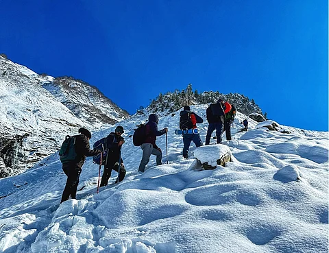 A group of Kashmir boys and tourists climbing a snow-clad mountain during a mountaineering expedition in winter season in Kashmir.