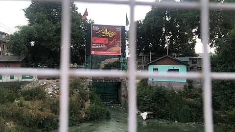 A banner erected on the flow gate between Dal Lake and river Jhelum near Gaw Kadal, Srinagar, on Wednesday, June 25, 2025.