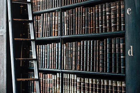 Historical books in a bookshelf in a library. Representative image.