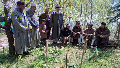 Family members and neighbours wait beside a grave prepared in their own lawn hoping to bring Rashid Ahmad Mughal home, even if only in death in village Chount Waliwar, Lar Ganderbal in central Kashmir.